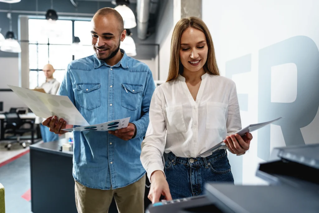 Two employees using new modern printer in office